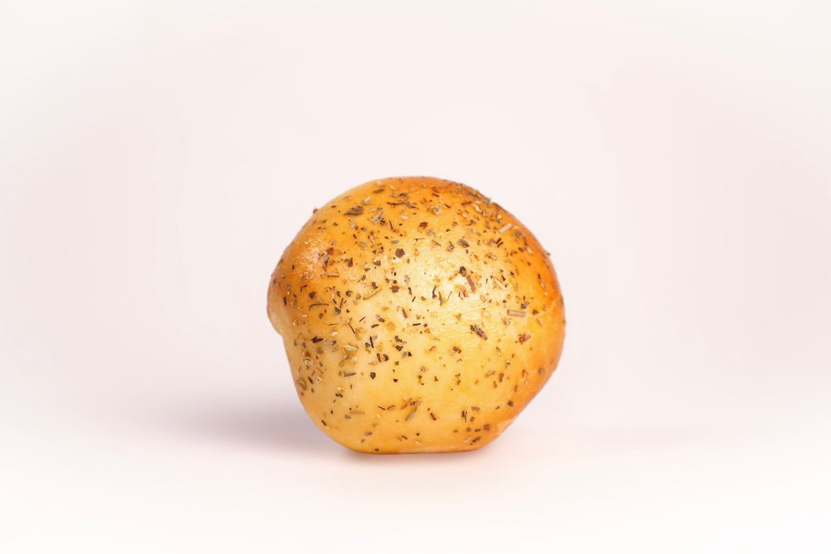 A single pepperoni pizza bagel bomb with a golden-brown crust, topped with Italian seasoning.