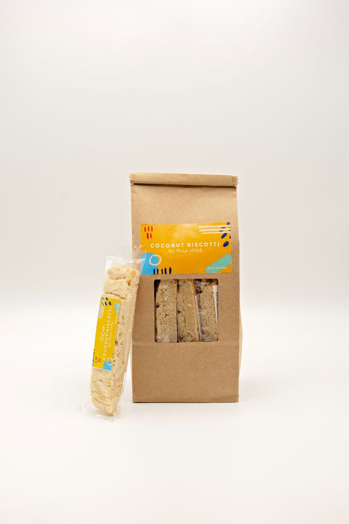 A package of Vegan Coconut Biscotti with a single packaged one leaning next to it